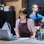 Colleagues, partners, man and woman behind counter in coffee shop