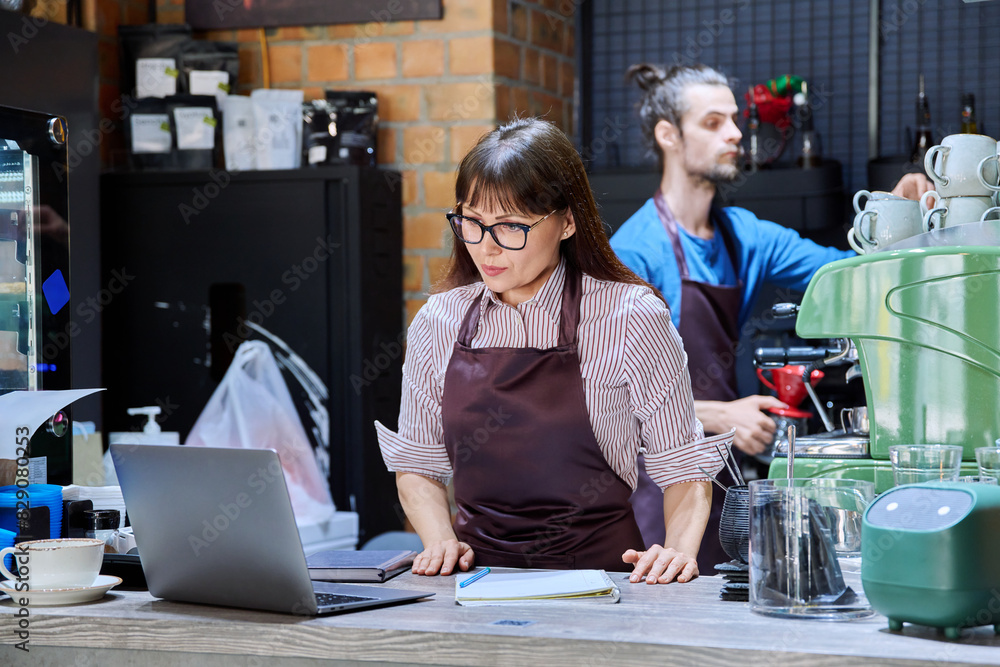 Colleagues, partners, man and woman behind counter in coffee shop